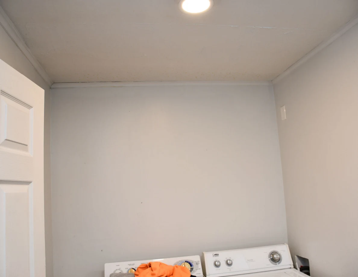 Upper wall and ceiling light above washer and dryer.