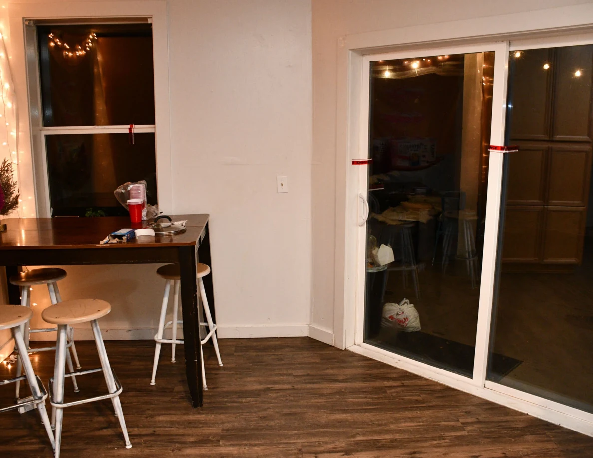 Kitchen sliding glass door beside tall table and stools.