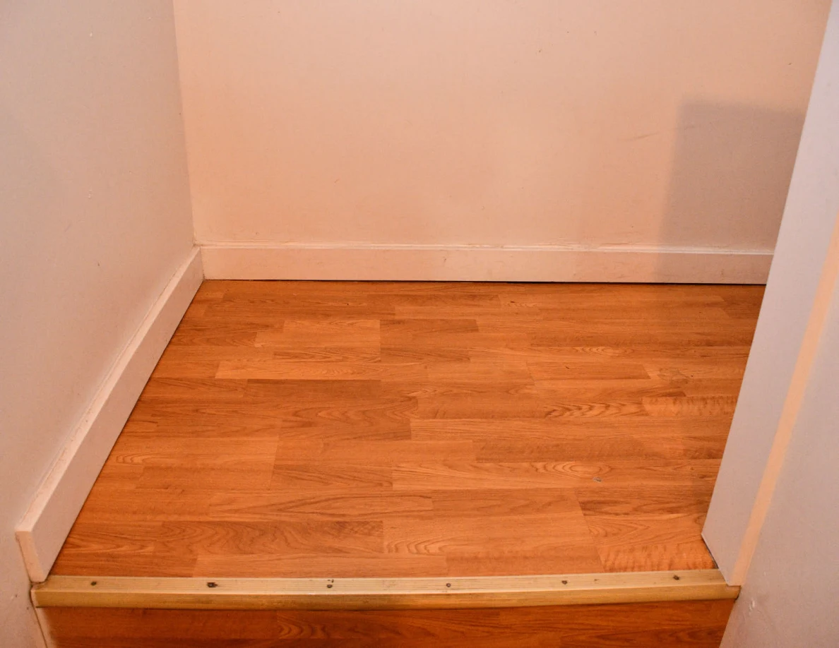 Wooden stair landing and plain walls.