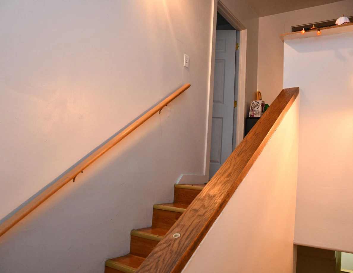 Upper staircase with handrail and doorway.