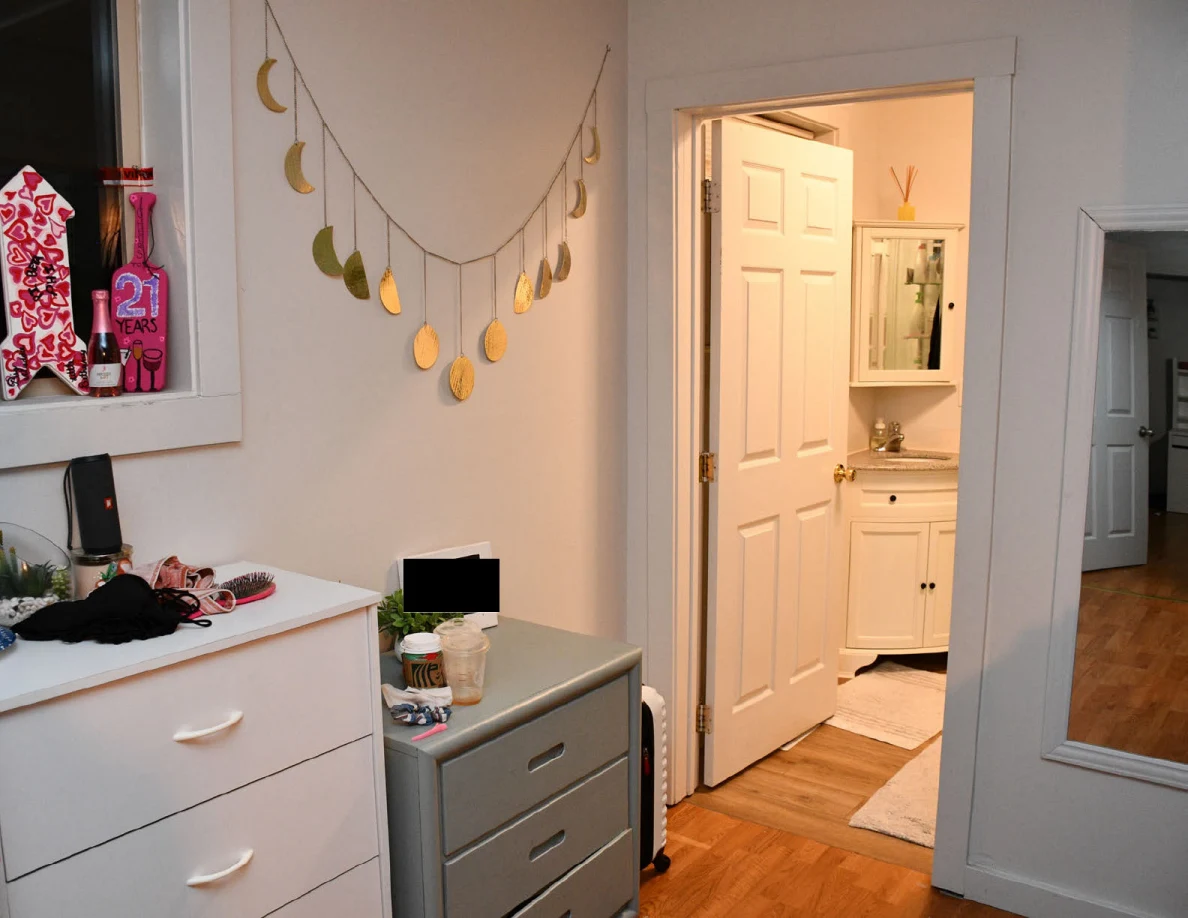 Drawer units beneath hanging moon-shaped decoration beside bathroom doorway.