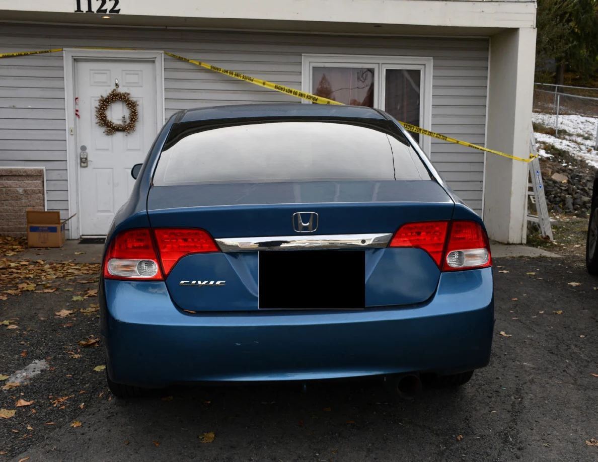 Rear of blue Honda sedan outside house number 1122.
