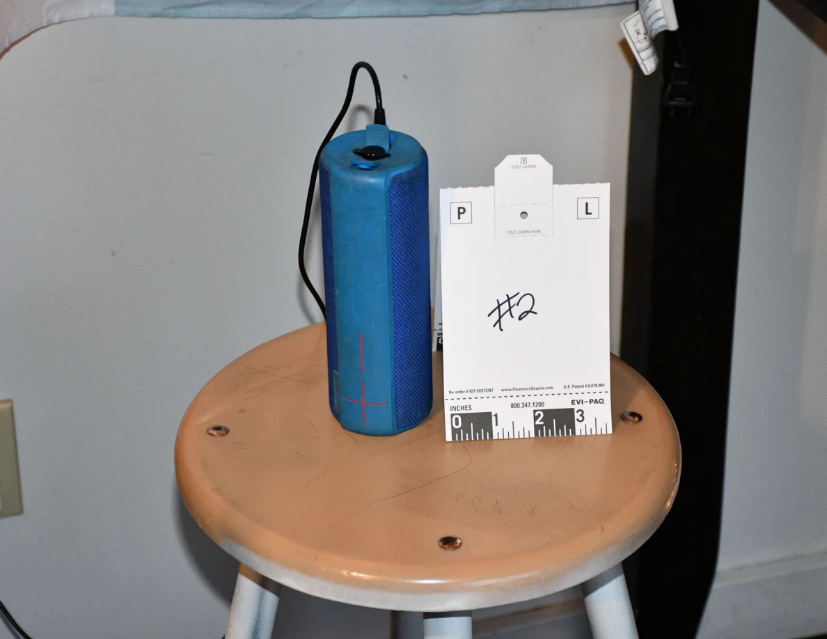 Blue cylindrical speaker beside reference card #2 on a stool.