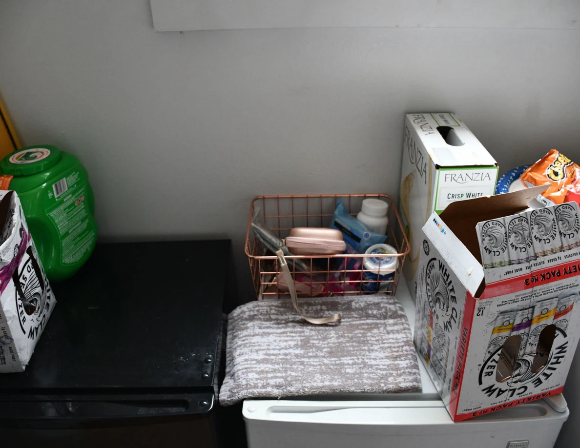 Compact refrigerator tops with wire basket, bottles and drink packaging.