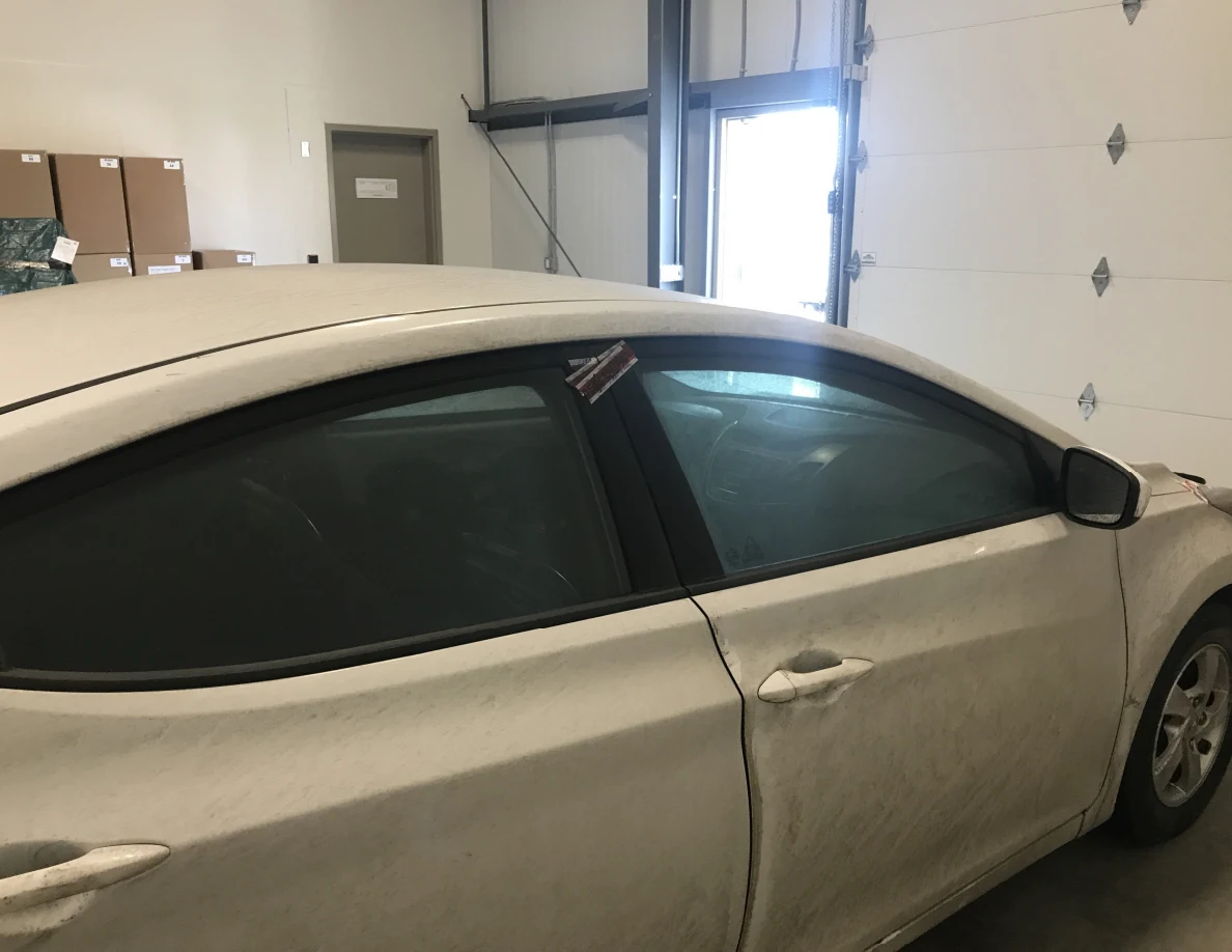 White car side windows and passenger doors indoors.
