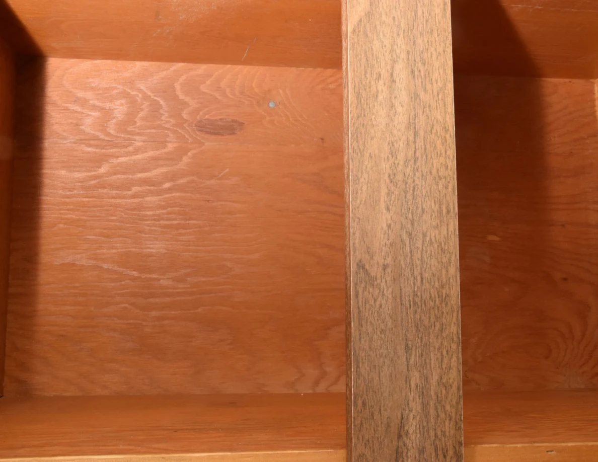 Empty wooden cupboard compartment with a center divider and visible wood grain.