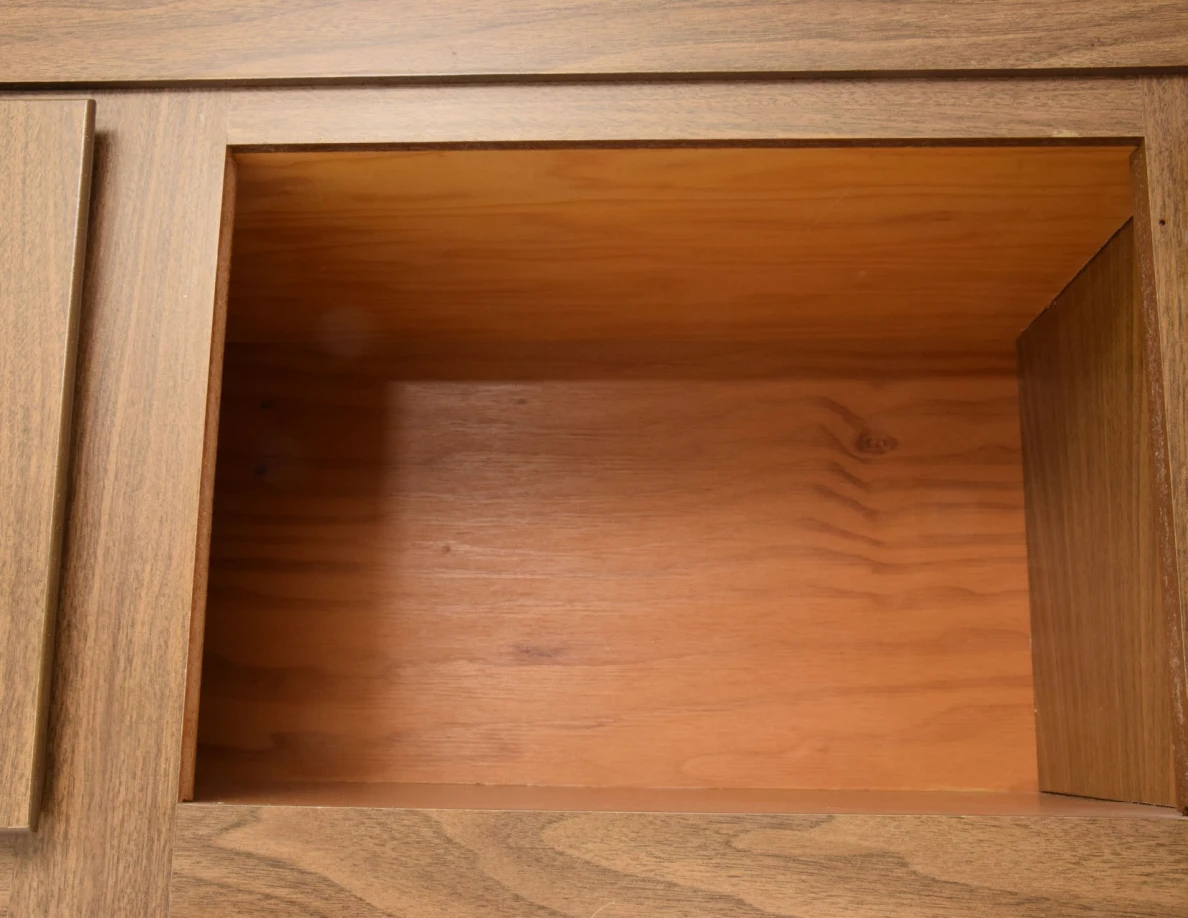 Empty upper wooden cupboard compartment with visible wood grain.