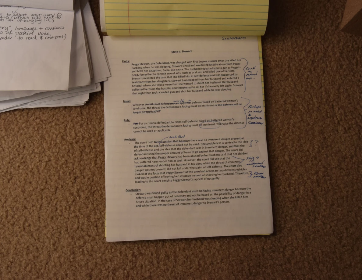 Printed interview-question page with handwritten annotations beneath a folded-back legal pad.