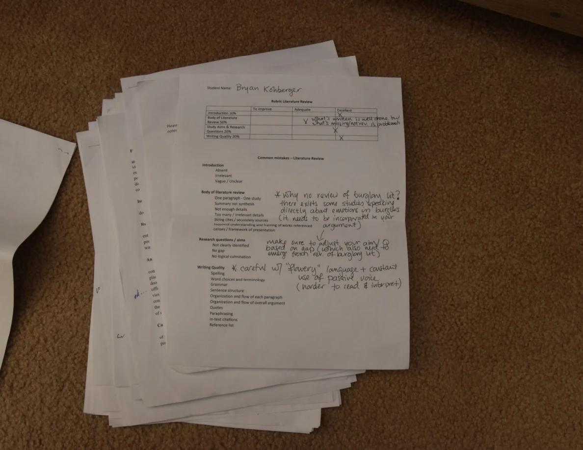 Annotated evaluation form with a table at the top on a stack of papers.