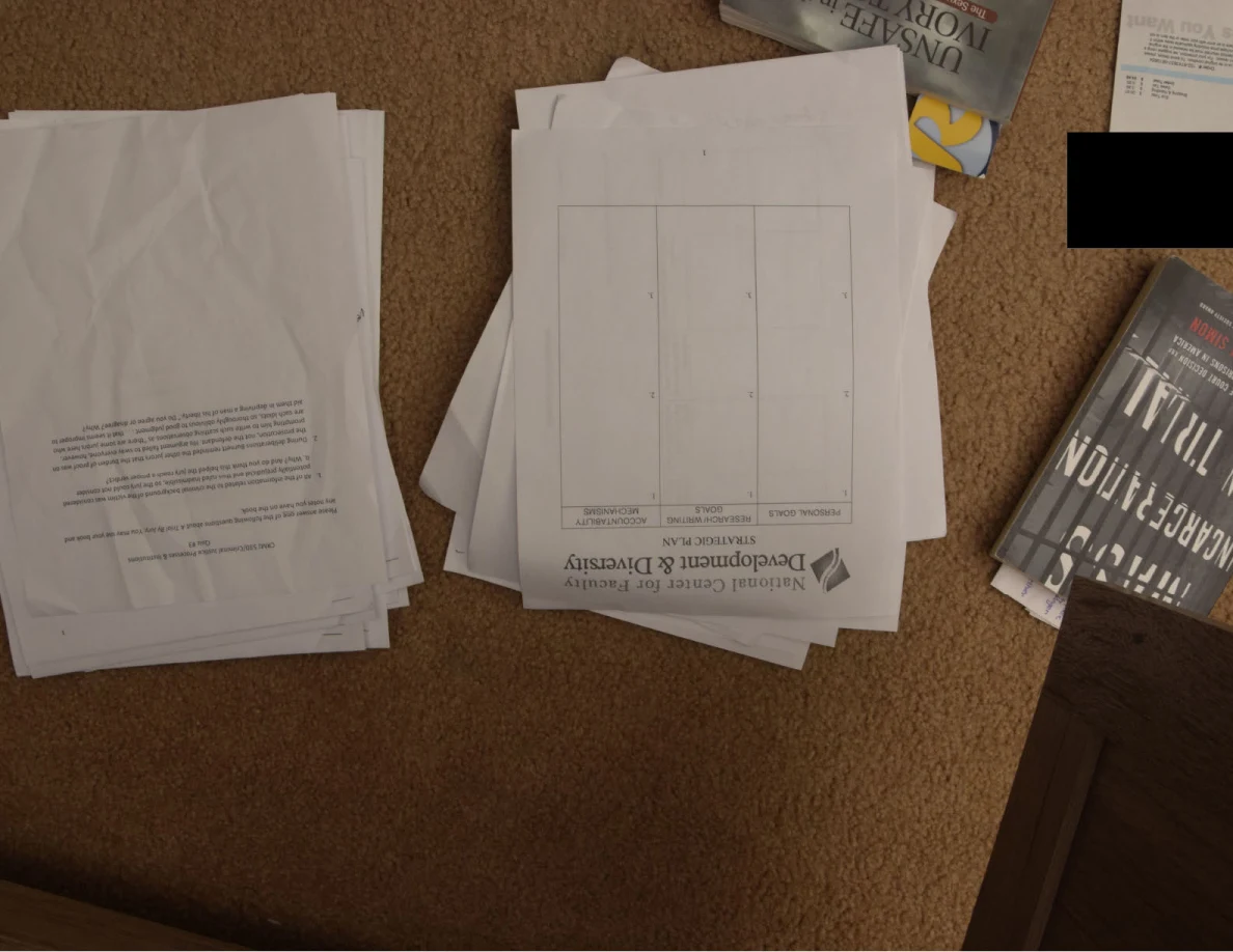 Two stacks of papers beside books, including a page headed National Center on Intensive Intervention with an evaluation table.