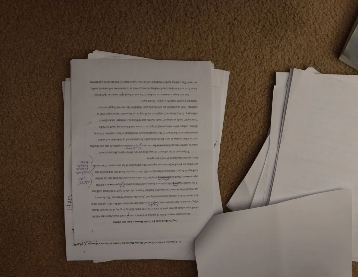 Upside-down essay page with dense handwritten corrections in the left margin.