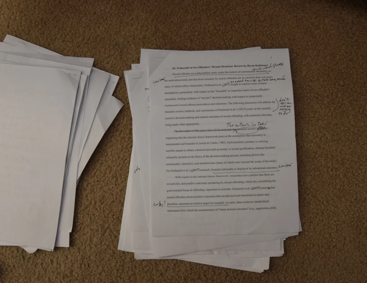 Printed essay page with handwritten notes across its top and margins.