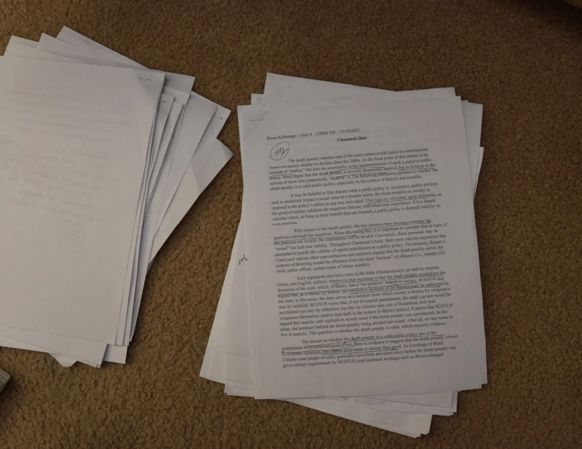 Printed Question One page with a circled handwritten mark near its heading, on a paper stack.