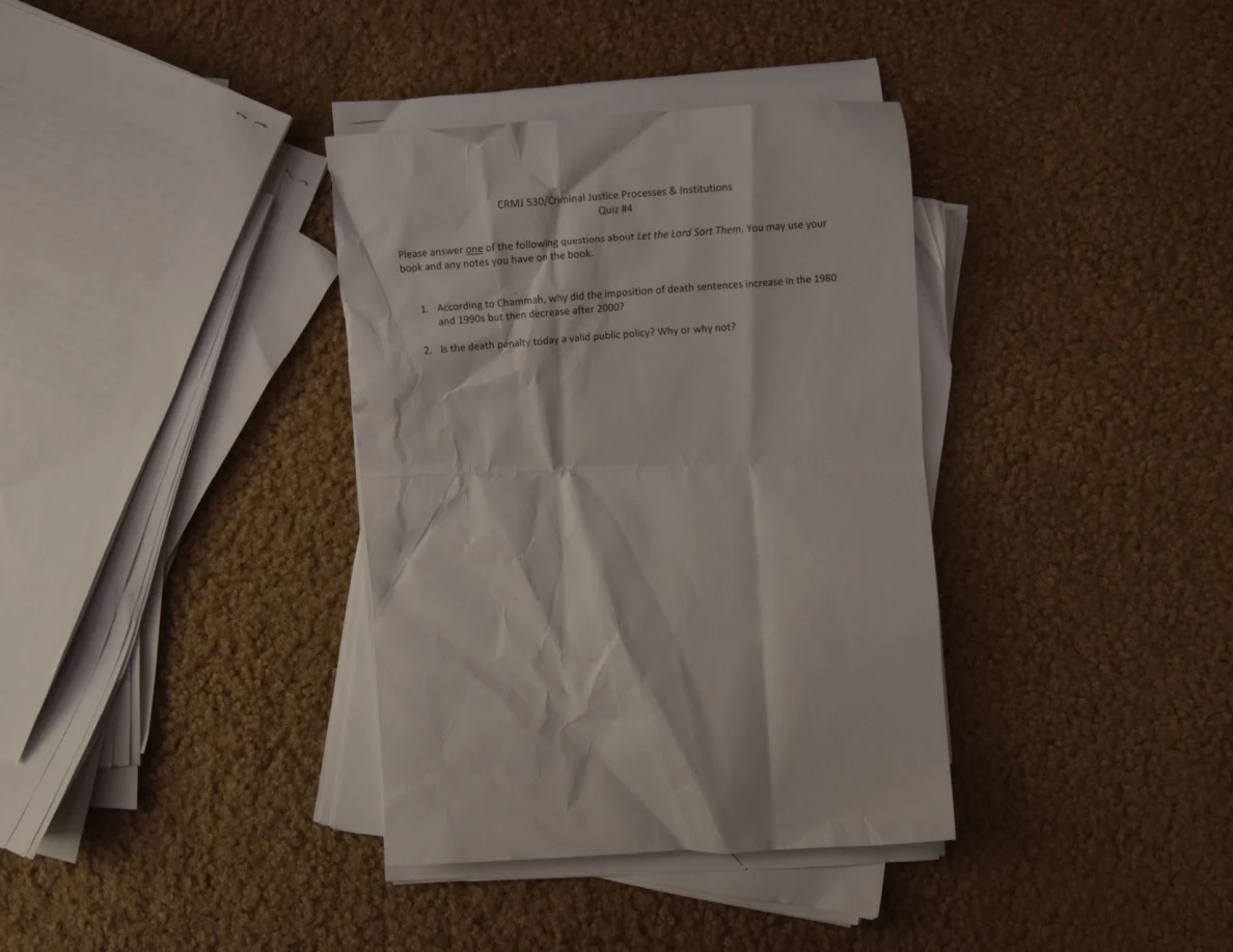 Creased printed quiz sheet with two questions near the top and blank space below.