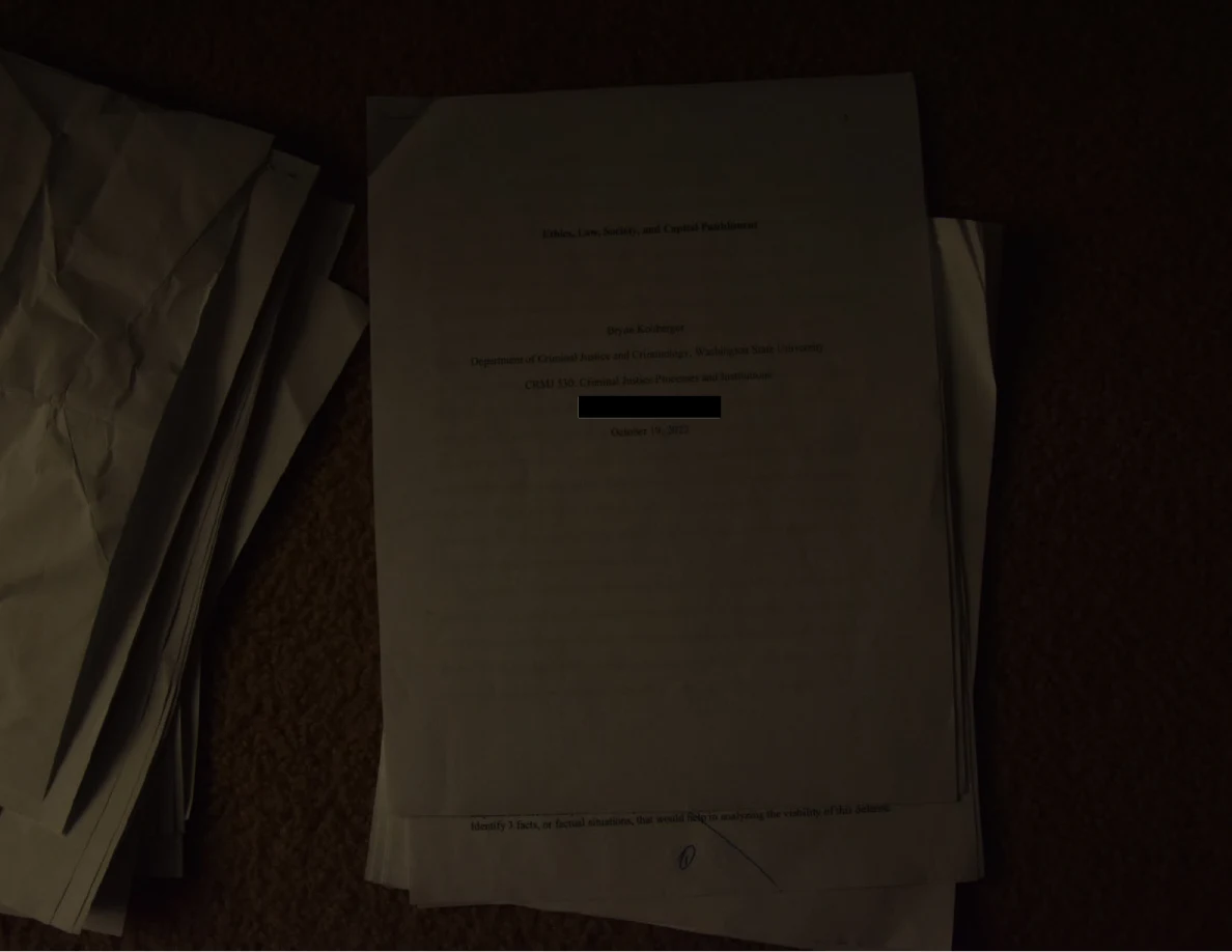Dim photograph of an academic cover page with a short black redaction bar.