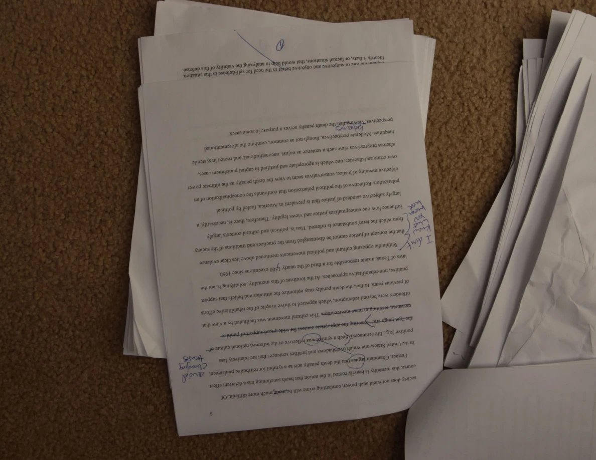 Upside-down printed essay page with handwritten notes in both margins.
