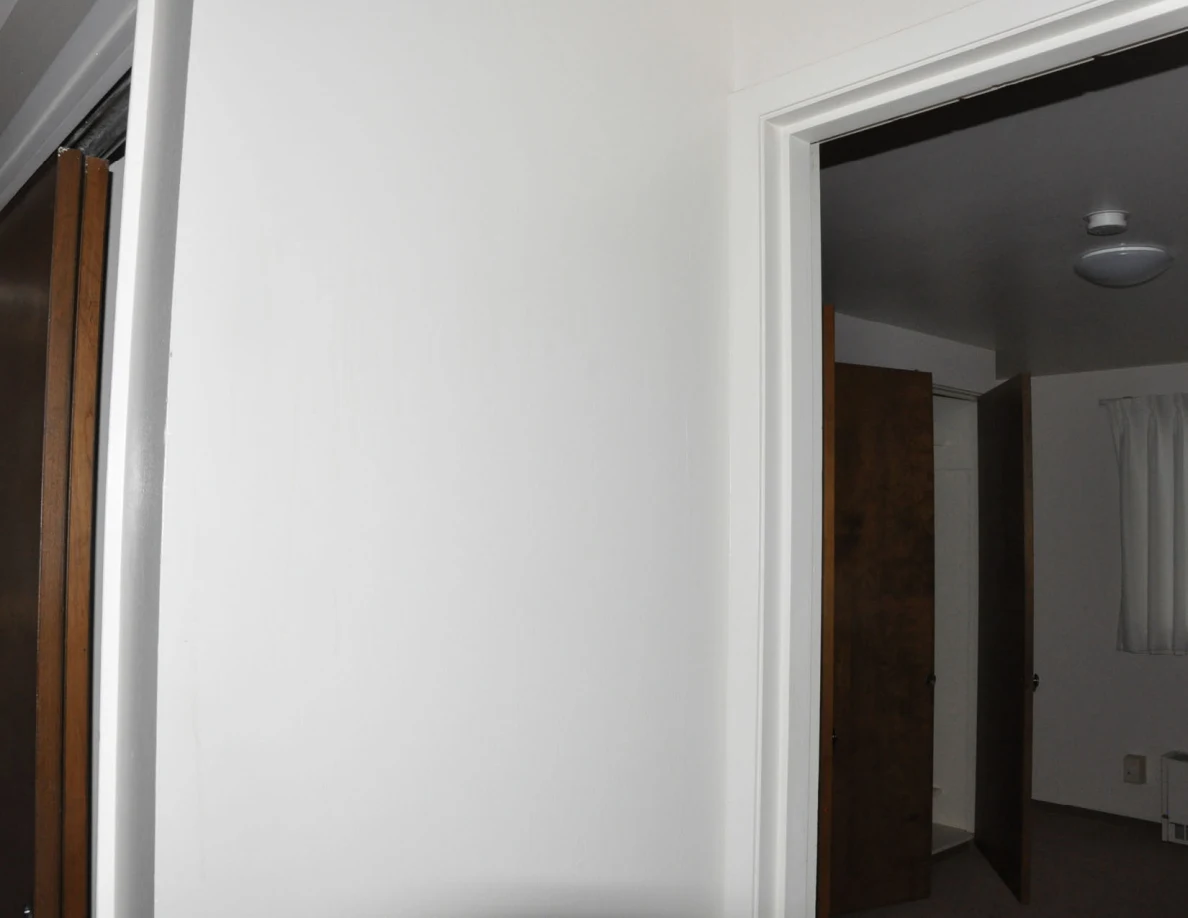 Upper interior doorway leading to a room with a ceiling light and wooden closet doors.