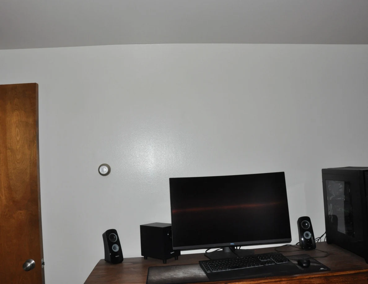 Desktop computer monitor, keyboard, speakers and tower on a wooden desk.