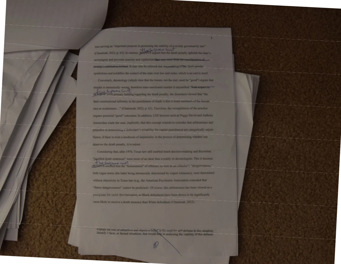 Photographed printed essay page with handwritten annotations and horizontal bands across the image.