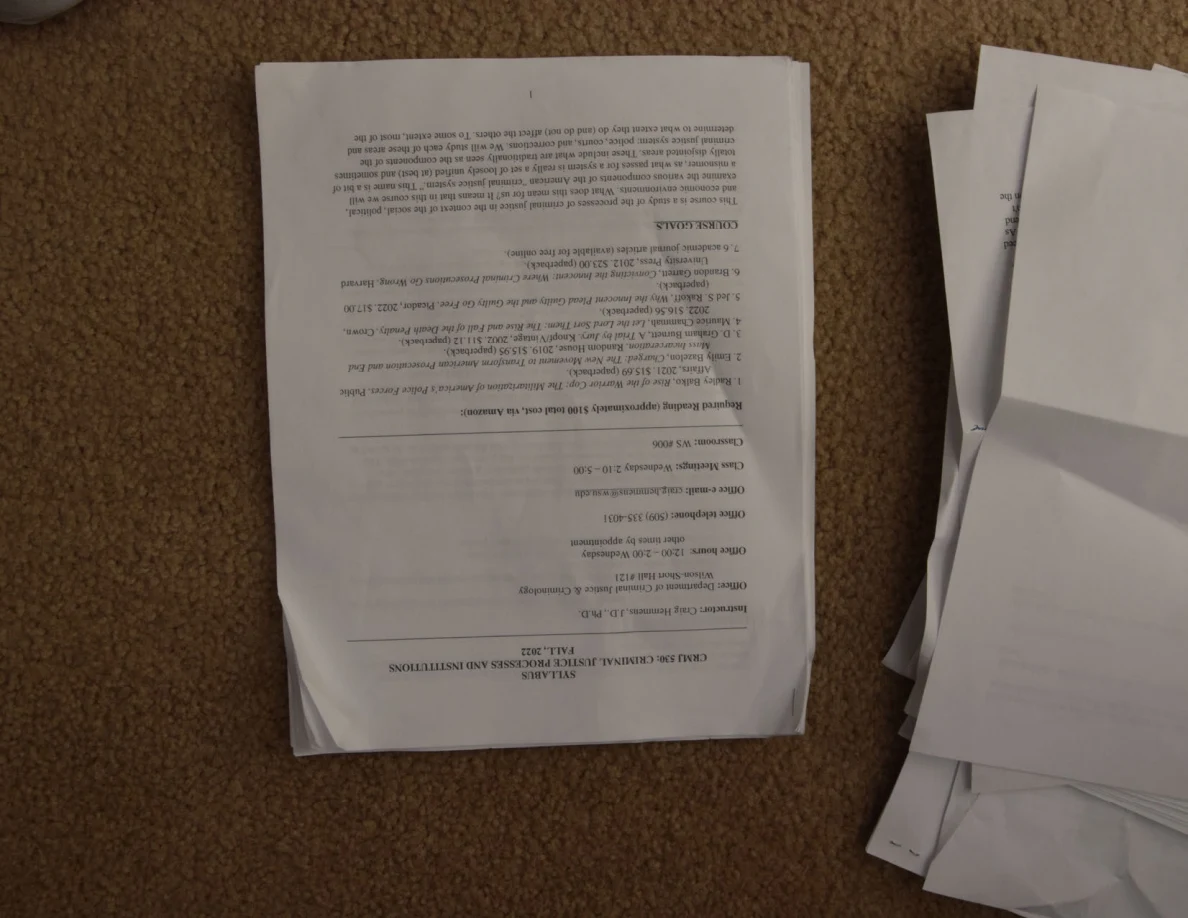 Upside-down printed course syllabus page with headings and paragraphs.