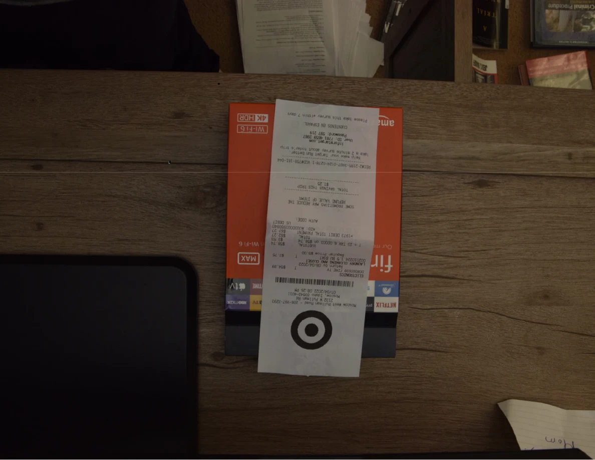 Store receipt laid over a Fire TV Stick box on a wooden cabinet.