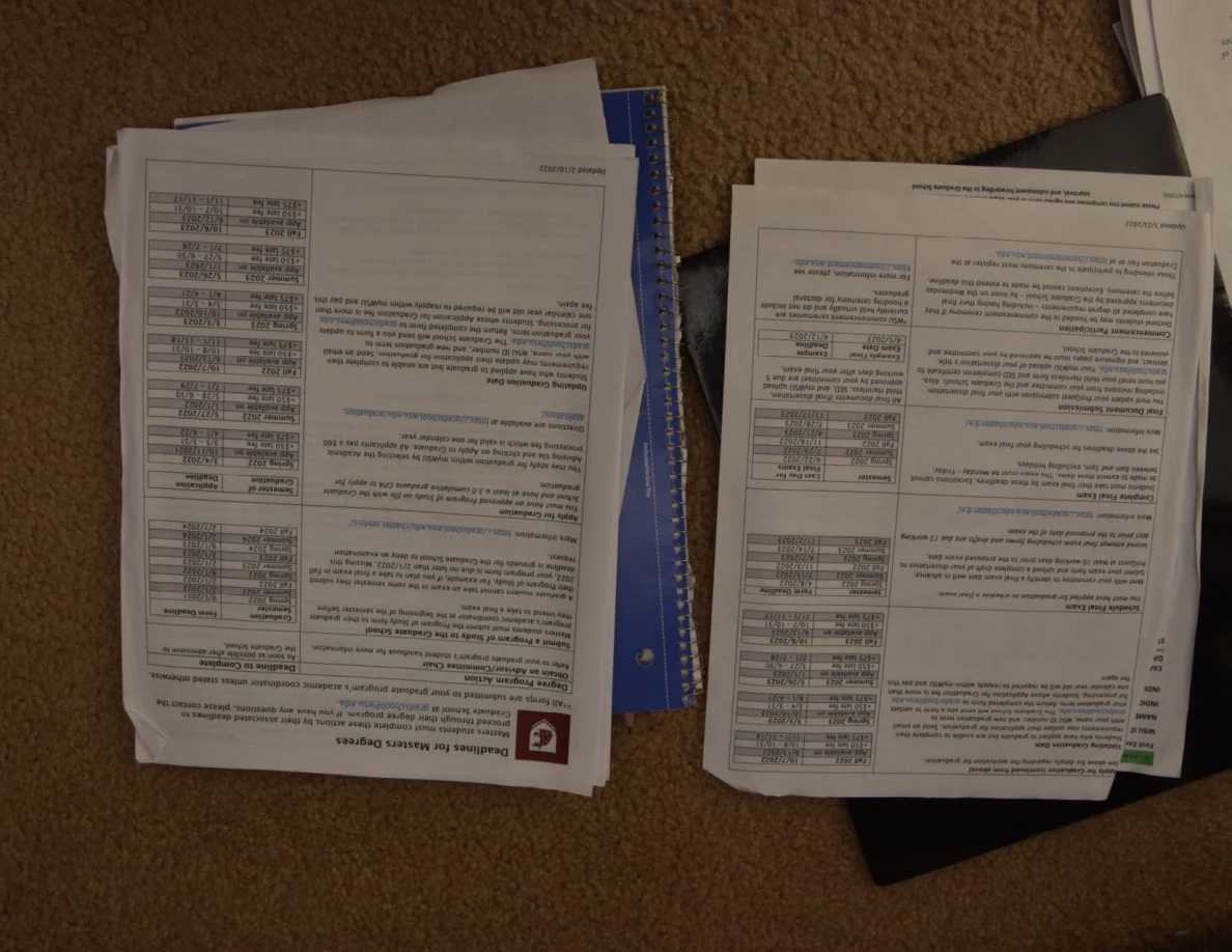 Two stacks of printed academic documents with tables and text.