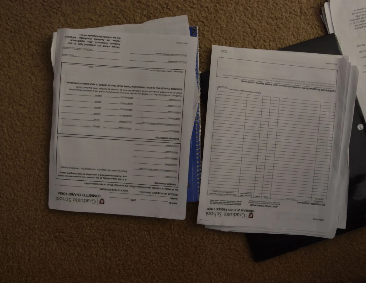 Two academic forms with blank tables, photographed upside down.