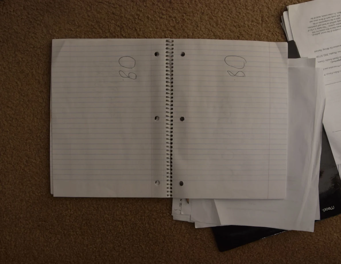 Open spiral notebook with sparse handwritten marks near the tops of both pages.