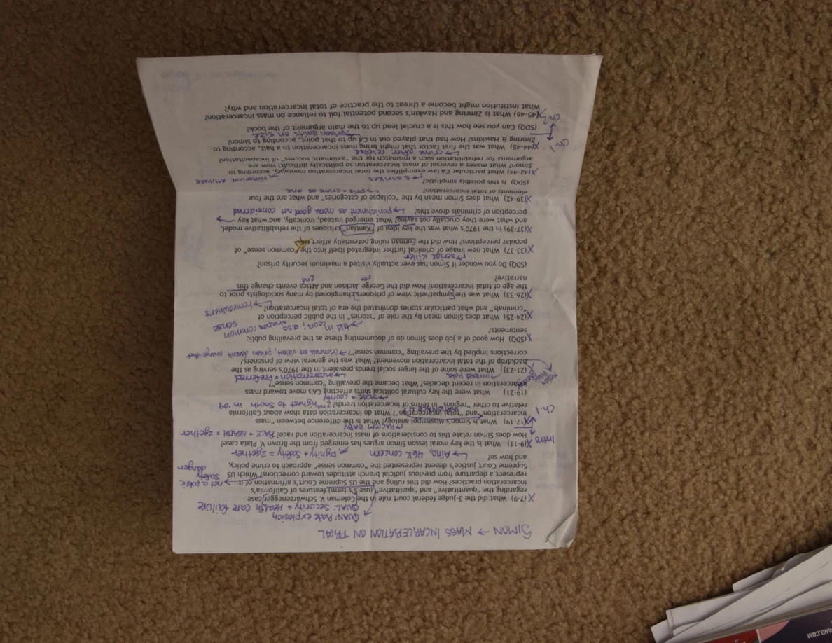 Upside-down printed reading notes covered with handwritten annotations.
