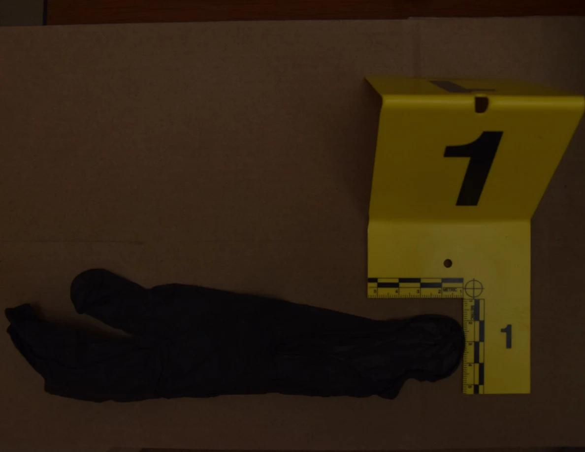 Close view of a black glove with yellow marker 1 and an L-shaped scale.