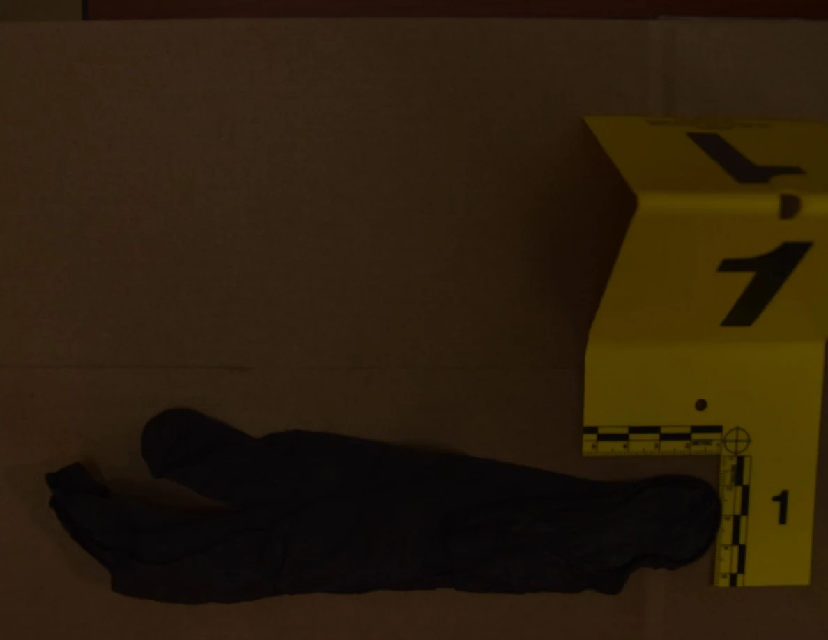 Black disposable glove lying flat beside yellow marker 1.