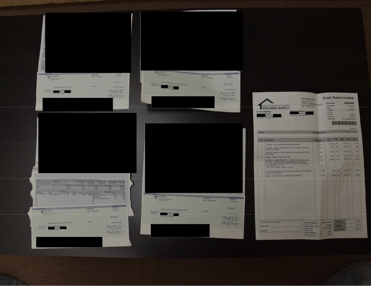 Redacted financial papers and a cash sales invoice arranged on a dark table.