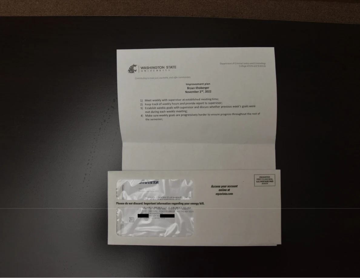 Washington State University letter and utility envelope on a table, with address details redacted.