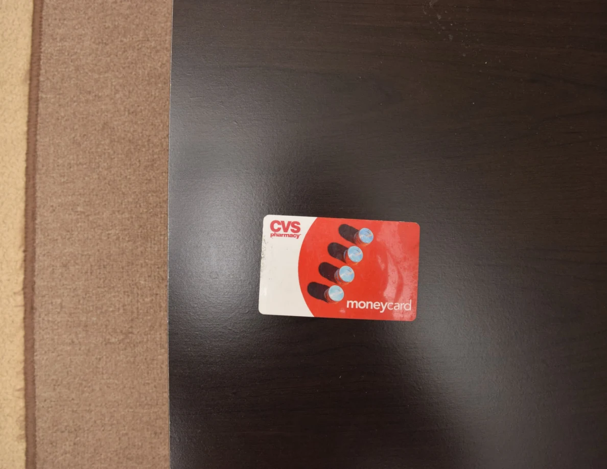Red and white CVS money card on a dark tabletop.