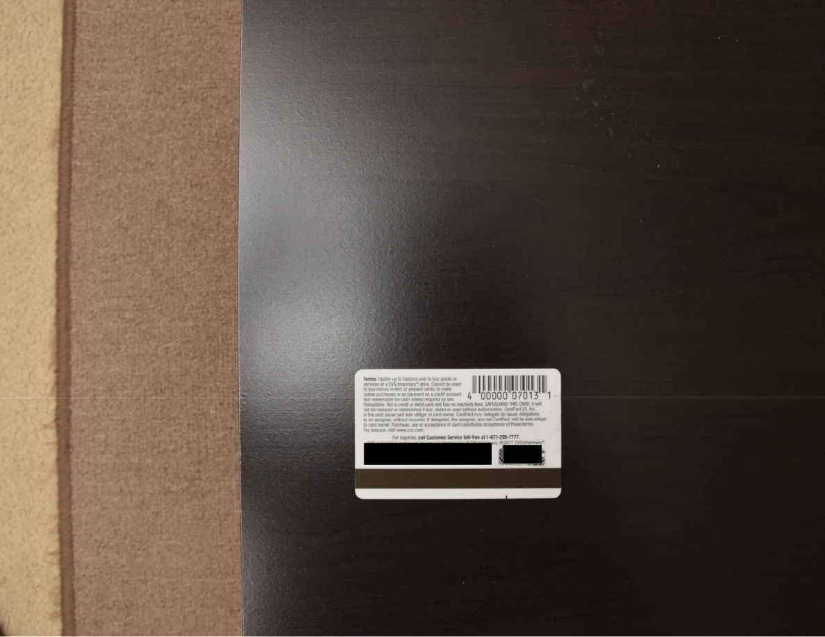Back of a card with barcode and blacked-out identifying numbers.