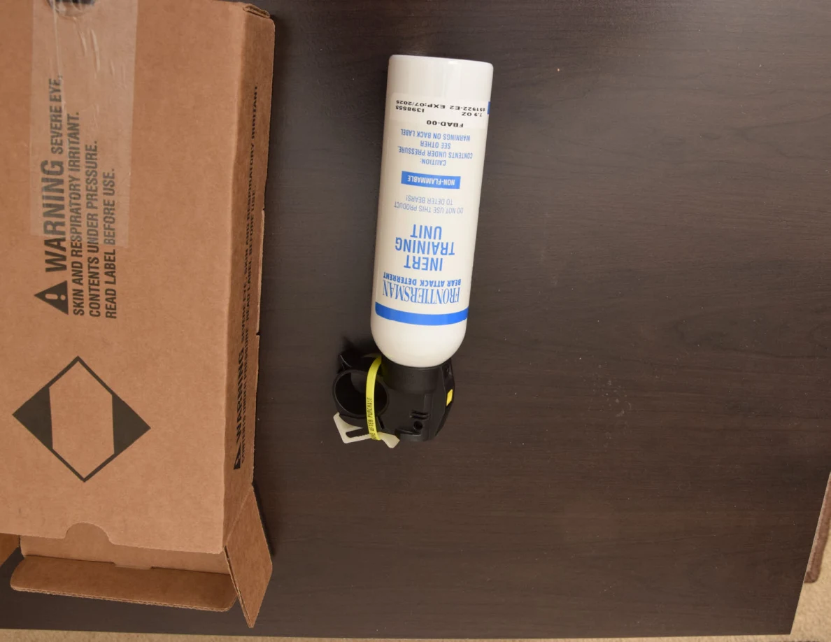 White training canister photographed upside down next to an open cardboard box.