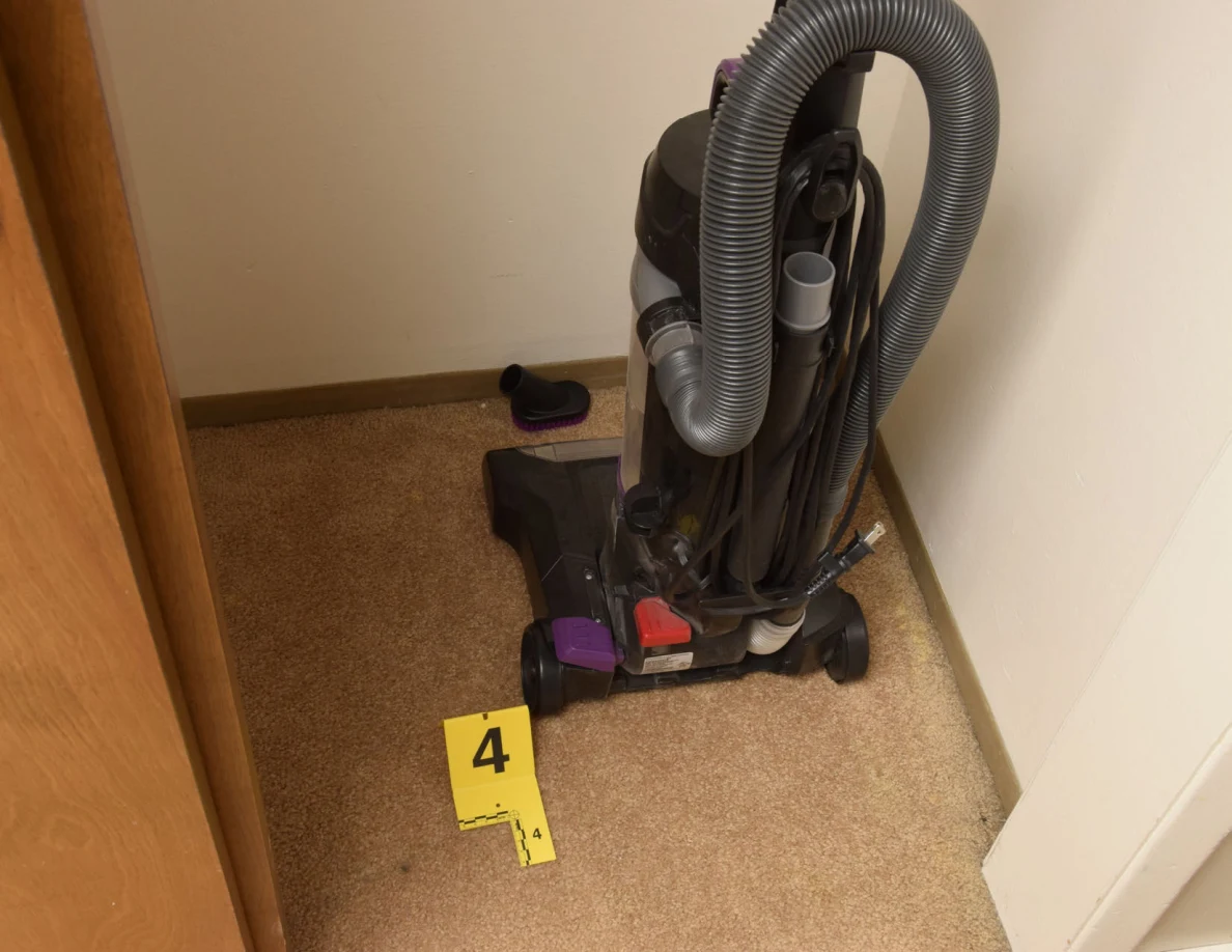 Back of an upright vacuum cleaner with coiled hose beside yellow marker 4.