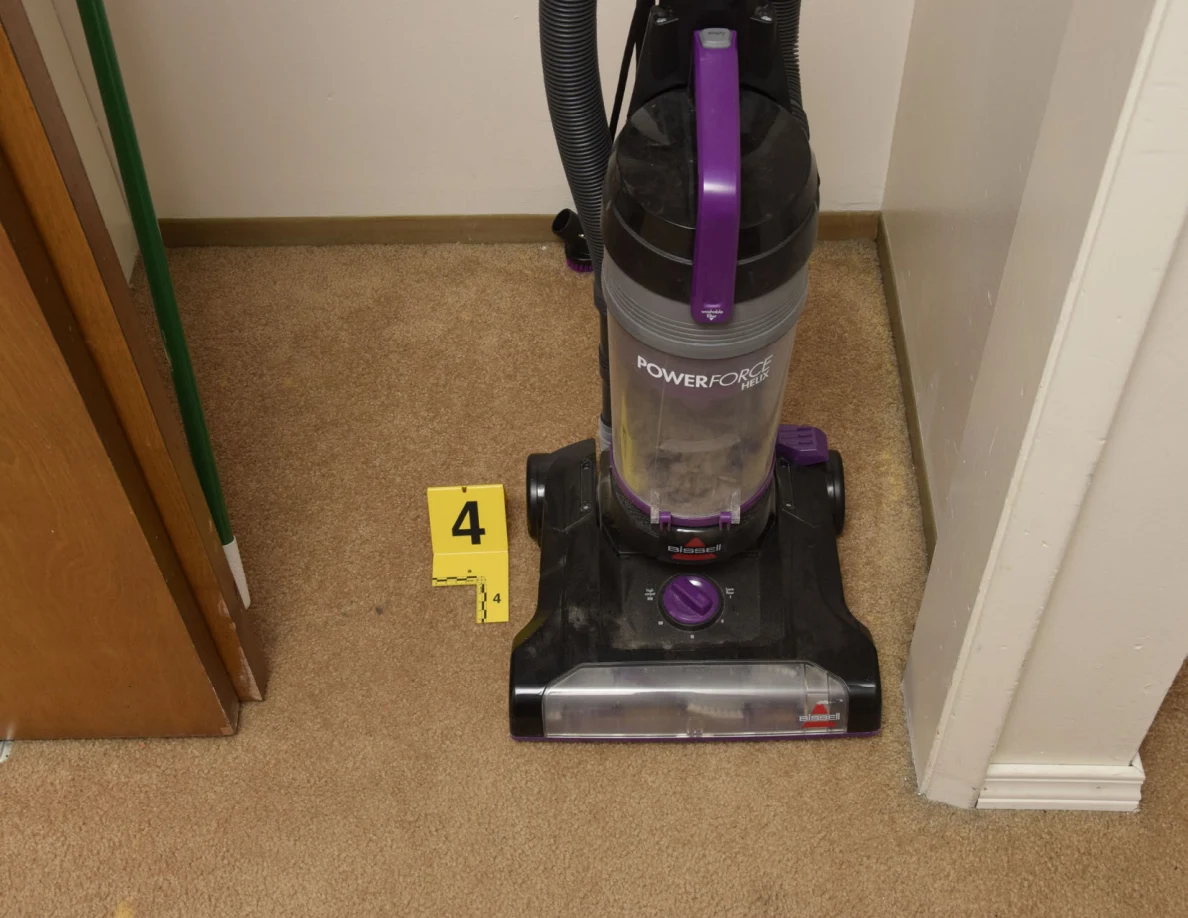 Front of a black and purple upright vacuum beside yellow marker 4.