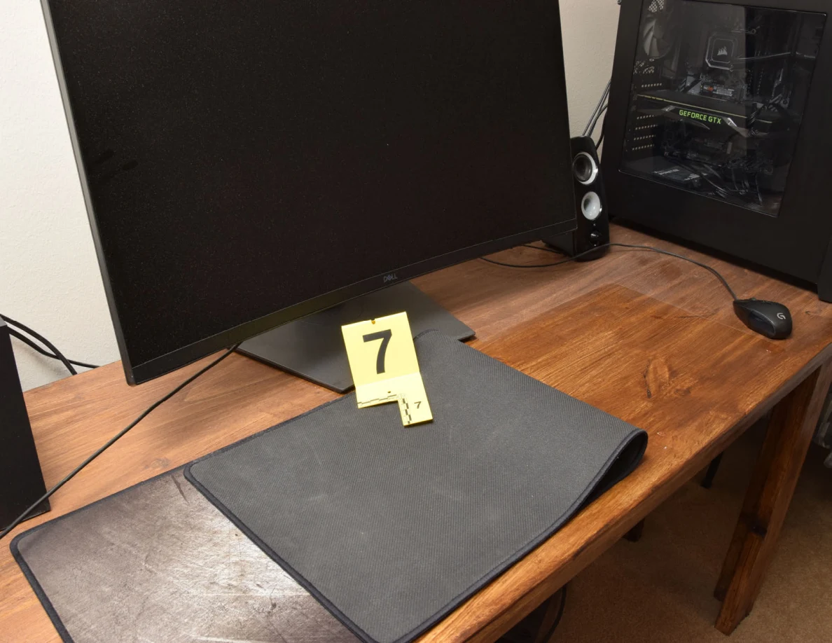 Folded black desk mat below a monitor beside yellow marker 7.