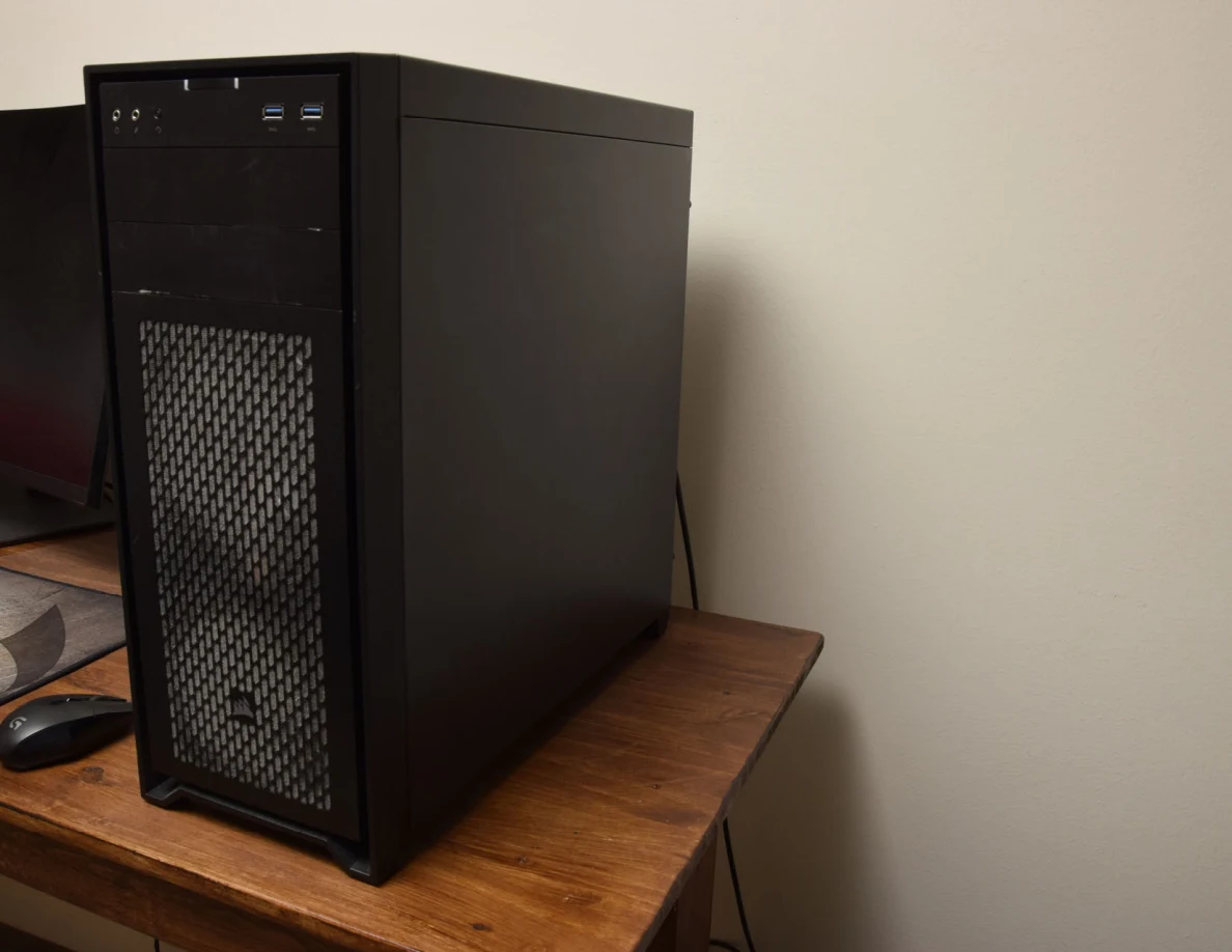 Angled view of a black desktop computer case on a wooden desk.