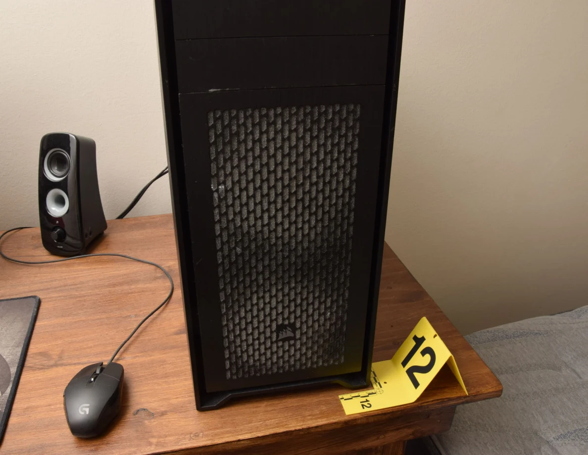 Close front view of a computer tower beside yellow marker 12 and a mouse.