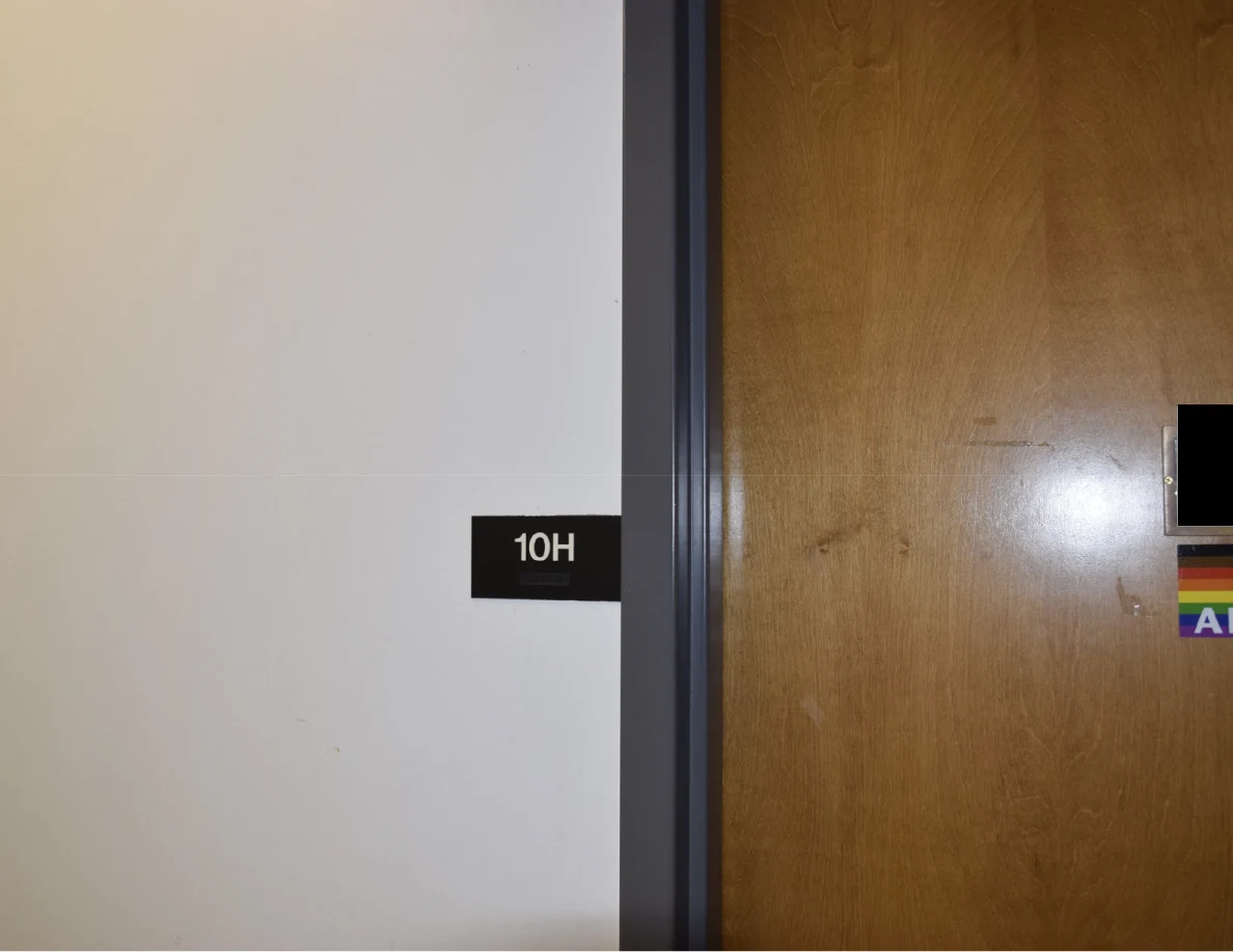 Office doorway with room label 10H and part of a wooden door.