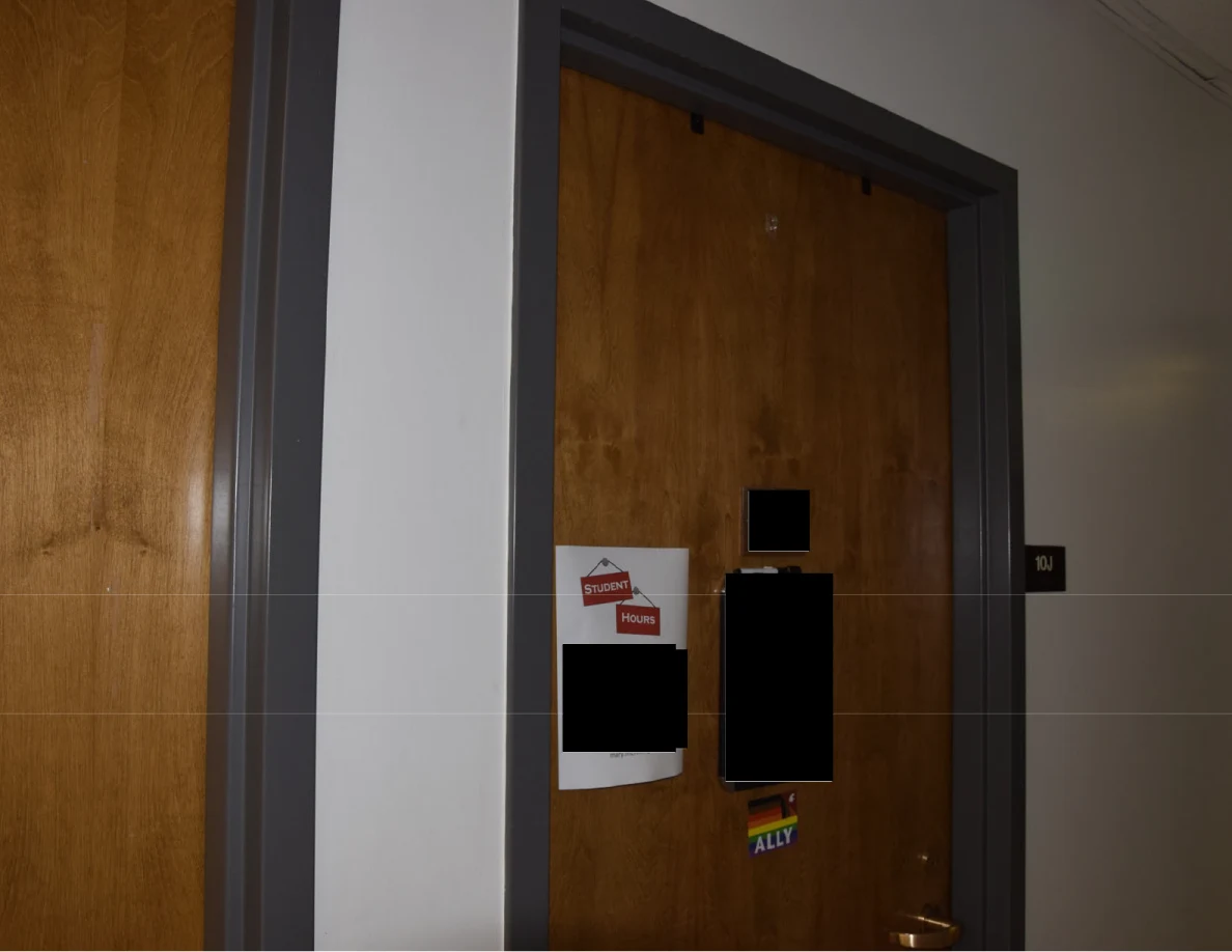 Wooden office door with posted notices and multiple black redactions.