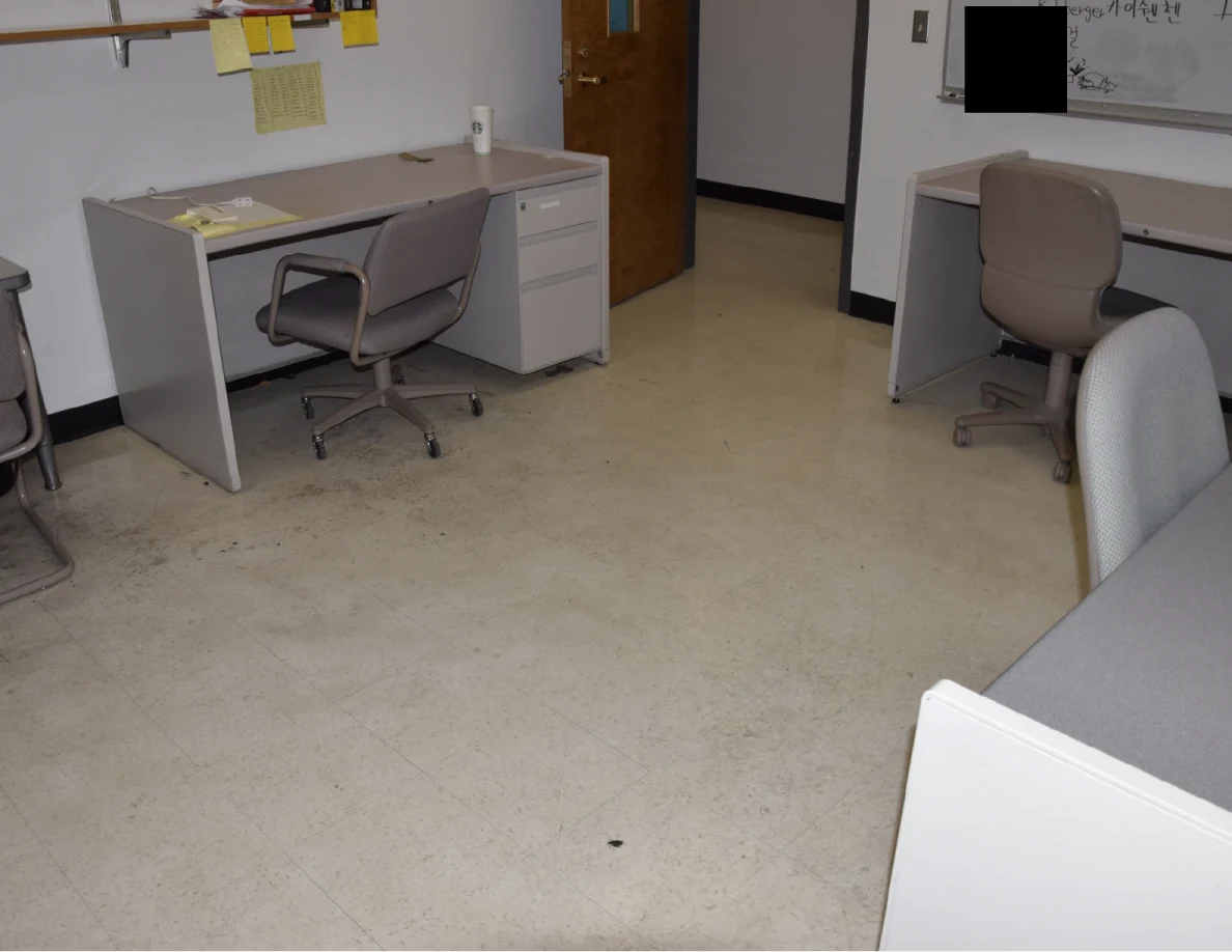 Pale office floor between desks and rolling chairs.