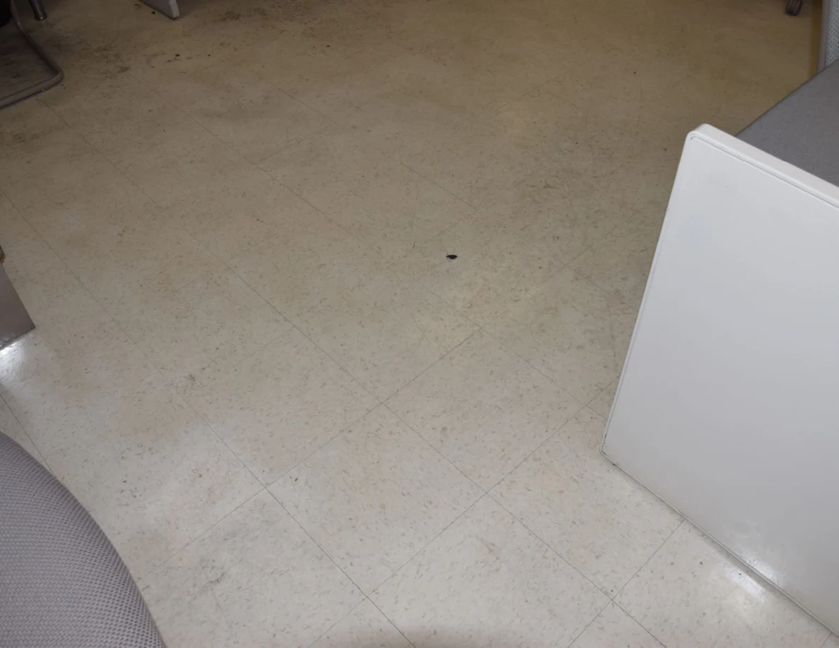 Close view of office floor tiles between desk corners.