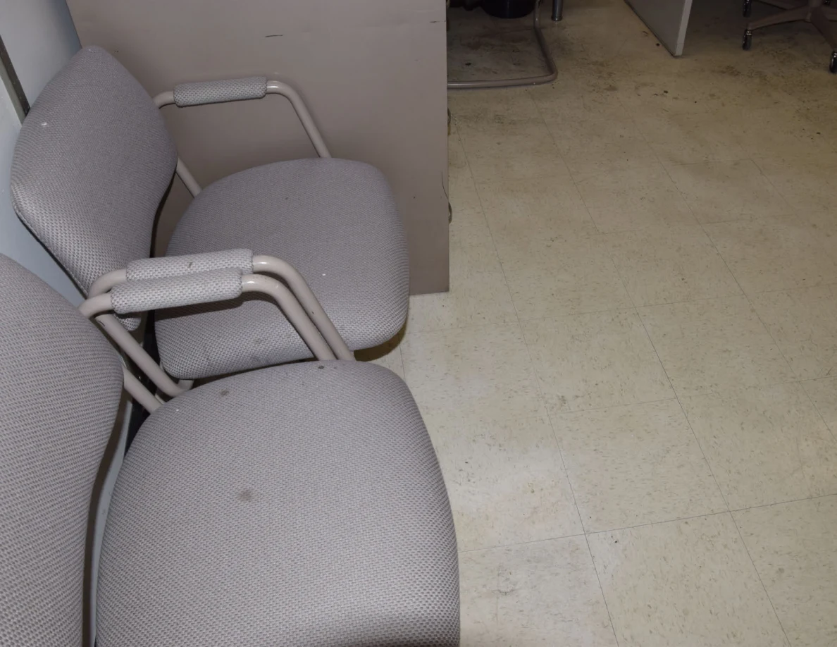 Two upholstered visitor chairs beside a filing cabinet.