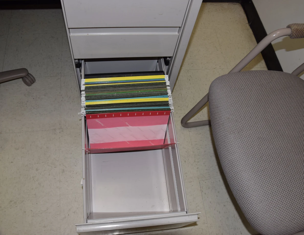 Open file drawer with several colored hanging folders.