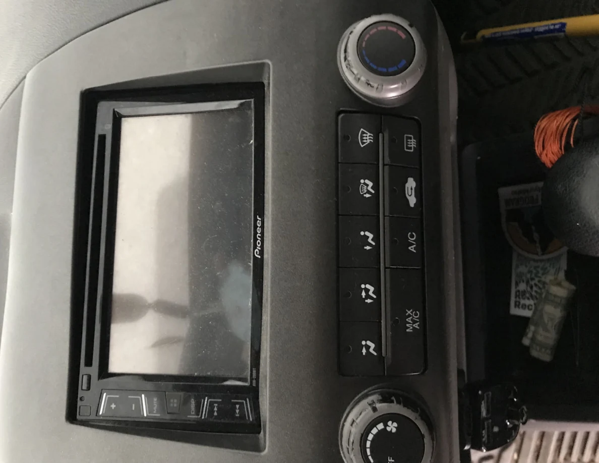 Car dashboard with a Pioneer touchscreen and climate-control knobs, photographed sideways.