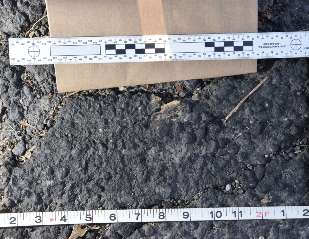 Textured asphalt patch framed by measuring scales, with an envelope above.