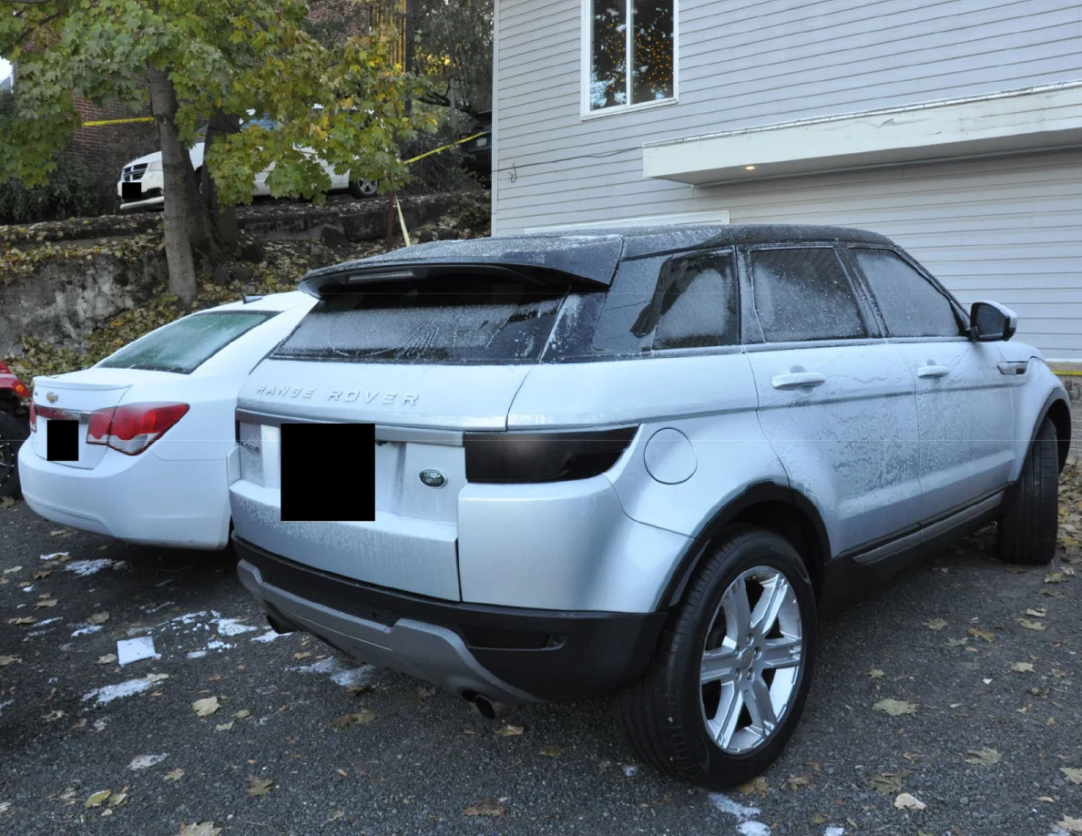 Silver Range Rover beside a white sedan, with a gray-sided house behind them.